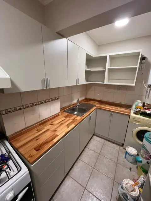 Cocina en L a medida con muebles en melamina gris claro y mesada de madera maciza, Córdoba