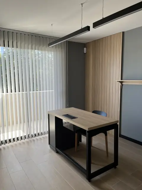 Puesto de trabajo a medida con escritorio de tapa símil madera y estructura metálica negra