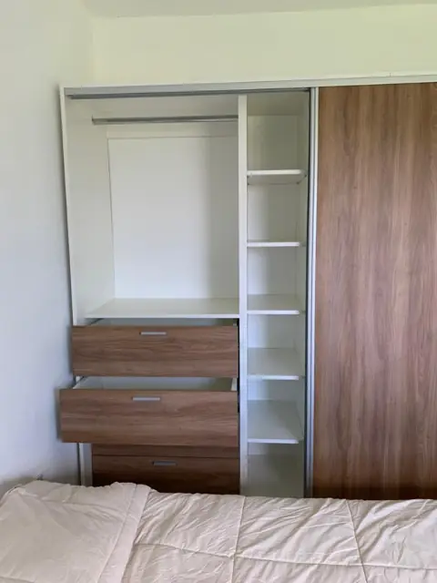 Placard a medida con puerta corrediza, cajonera y estantes interiores en melamina blanca y símil madera