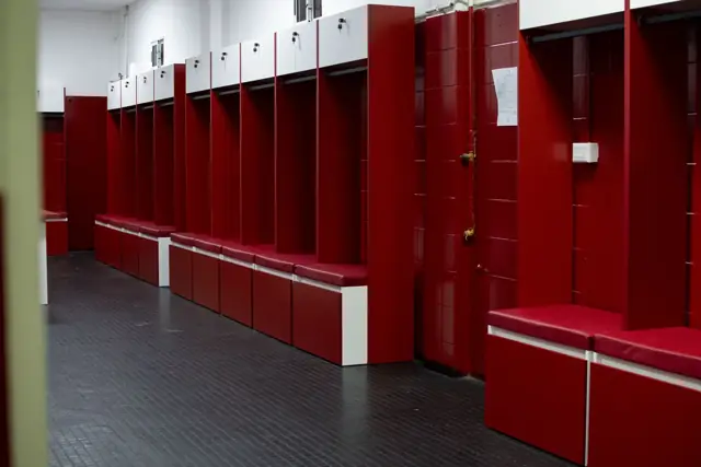 Vestuario del Club Atlético Instituto con lockers a medida en melamina roja y blanca y bancos tapizados