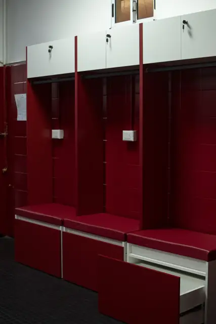 Detalle de lockers a medida con cajones bajo banco tapizado en el vestuario del Club Atlético Instituto
